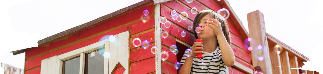 Junge in einem Gartenhaus, der Seifenblasen macht